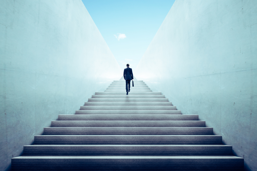 Um homem subindo uma escada, representando o caminho para o sucesso.